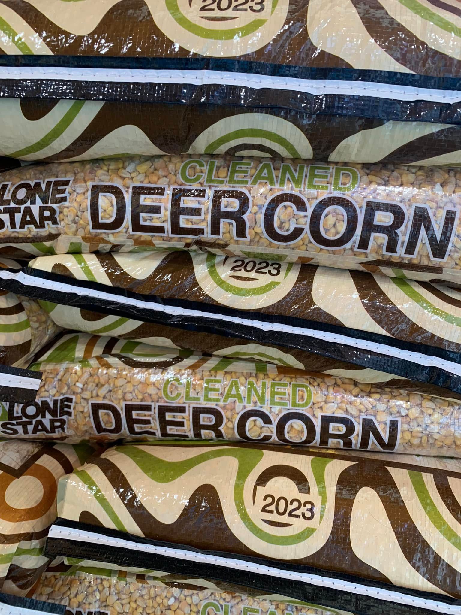 Close-up of green and brown deer corn bags stacked on a shelf with 2023 labels