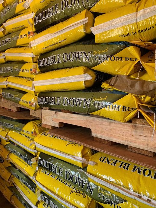 Stacks of yellow and brown bagged material piled on wooden pallets in a warehouse