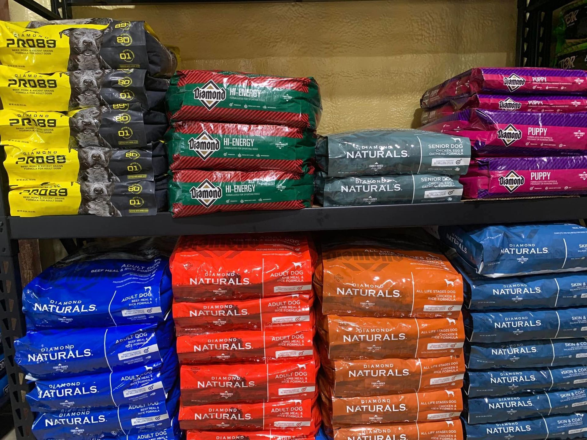 Shelves stocked with neatly stacked colorful packaged pet food bags in a store aisle