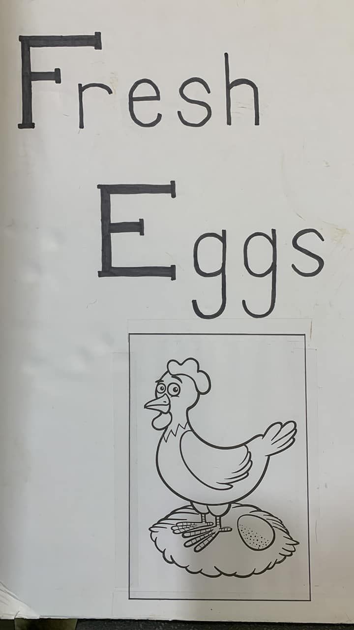 Sign reading “Fresh Eggs” with a black-and-white drawing of a hen on a nest