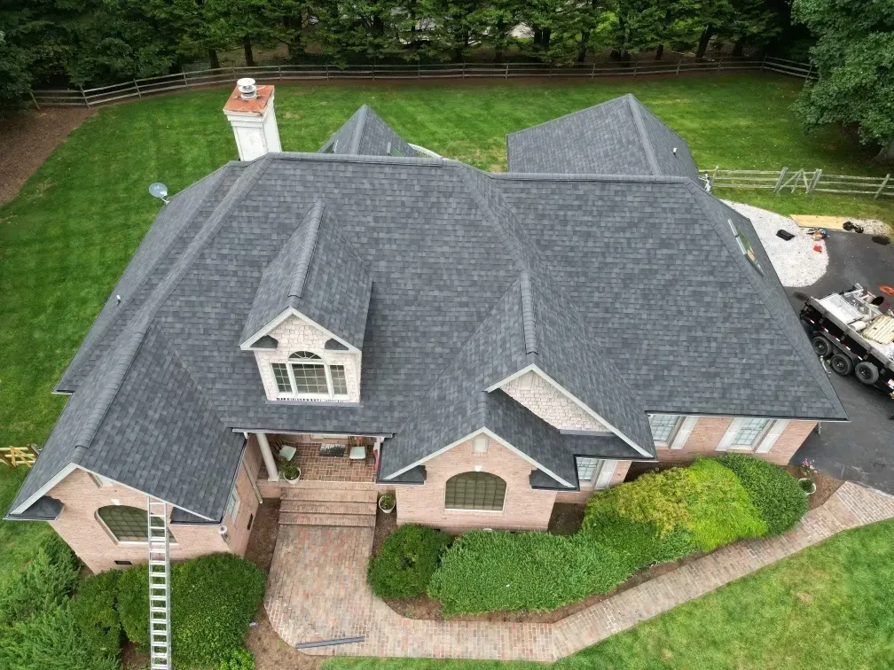 Red tiled roof with two skylights and a chimney under a blue sky