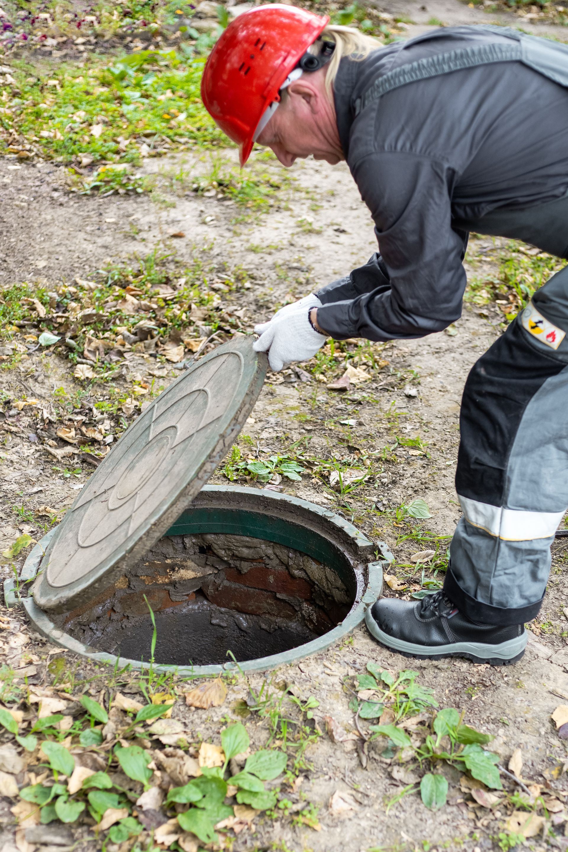 A man is opening a septic tank cover A man is opening a septic tank cover