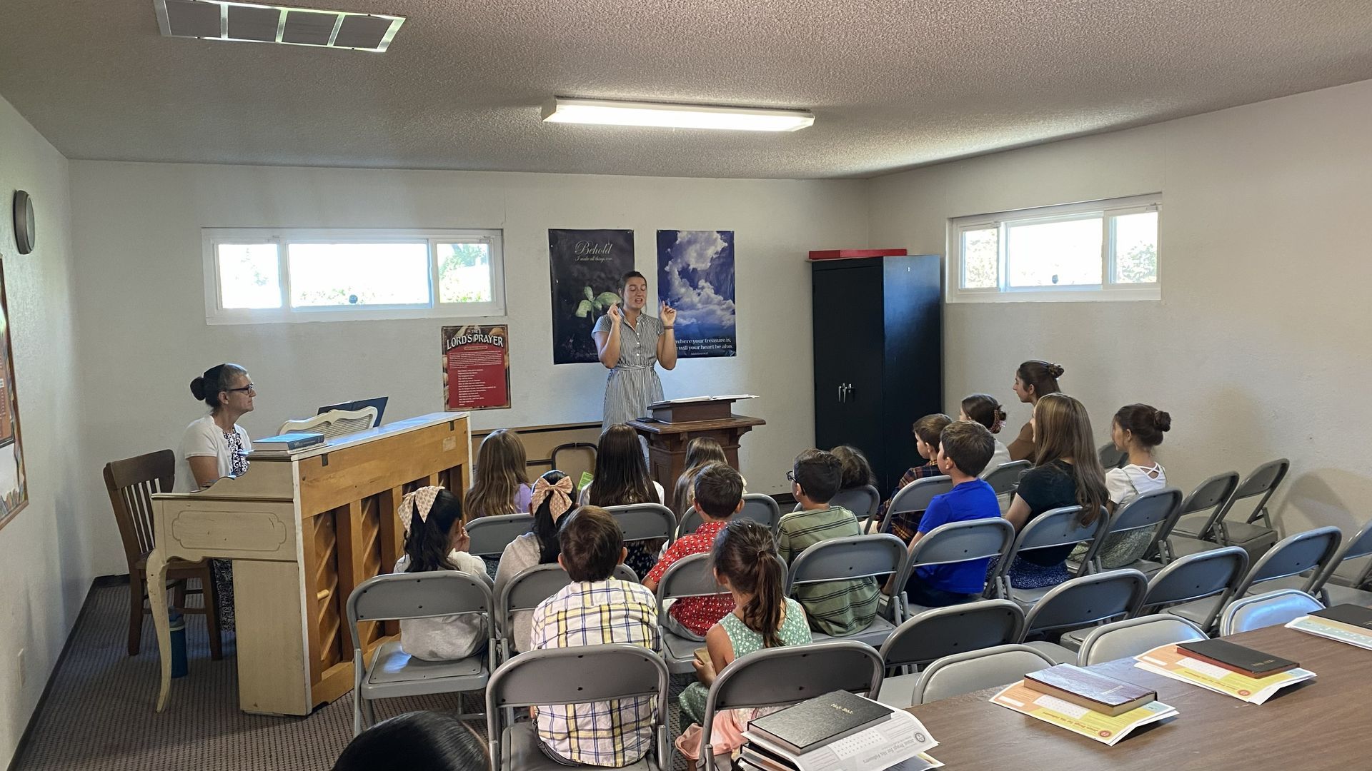 Small classroom gathering with a speaker at the front and seated audience listening attentively