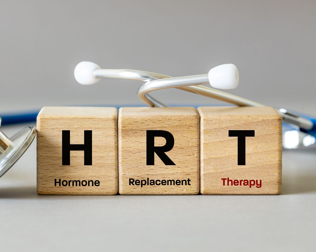Wooden blocks spelling HRT with stethoscope on a blurred desk background