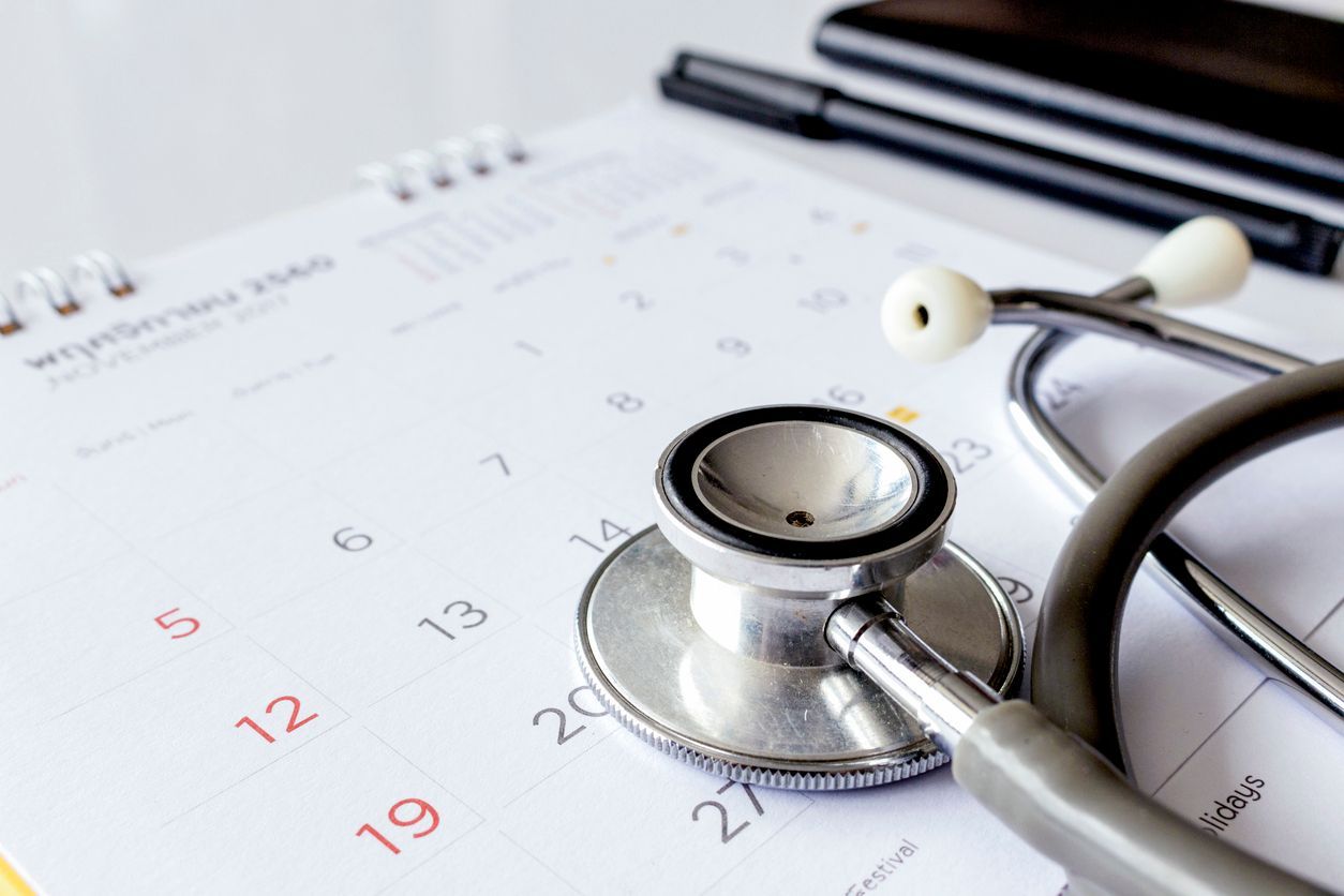 Stethoscope on a calendar with a pen, suggesting a medical appointment or health checkup.