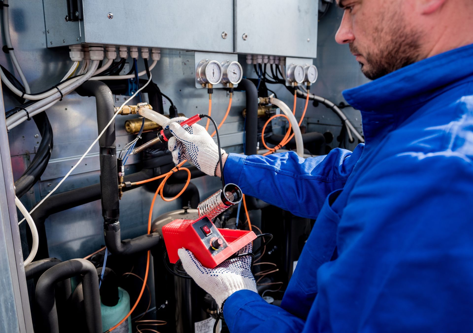 A Technician inspects gauges and wiring on a commercial electrical system.