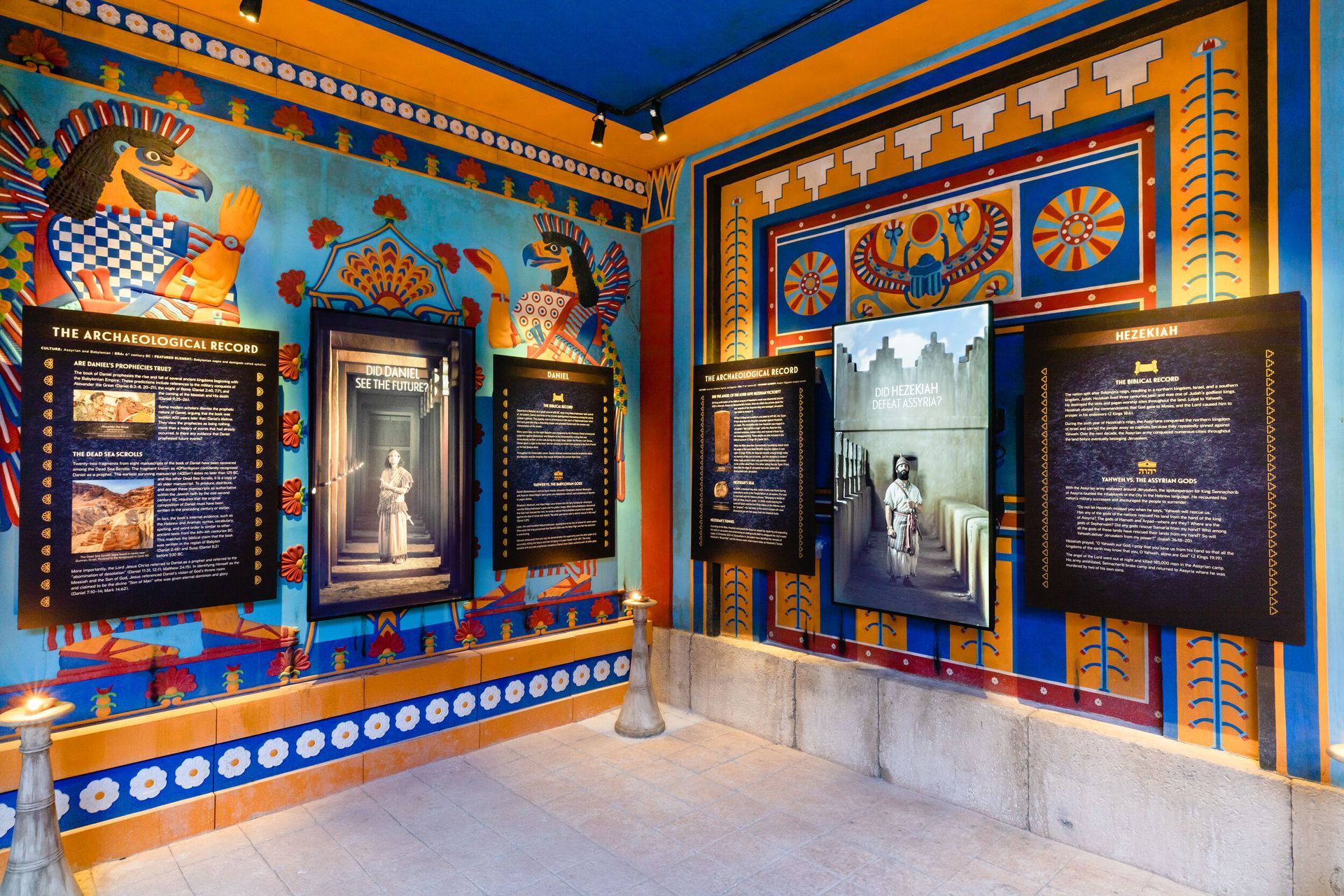 Brightly painted museum exhibit room with framed displays and a central mannequin-like figure
