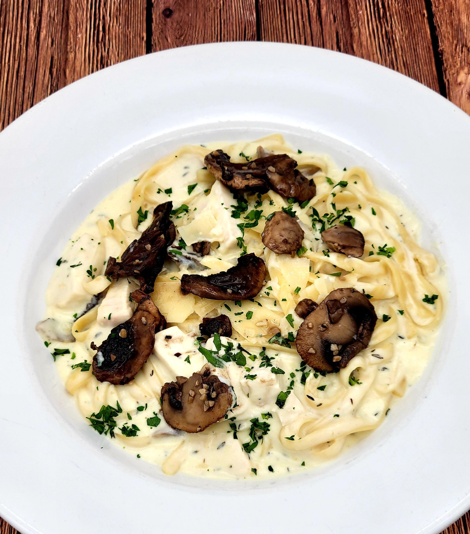 A white plate topped with noodles and mushrooms