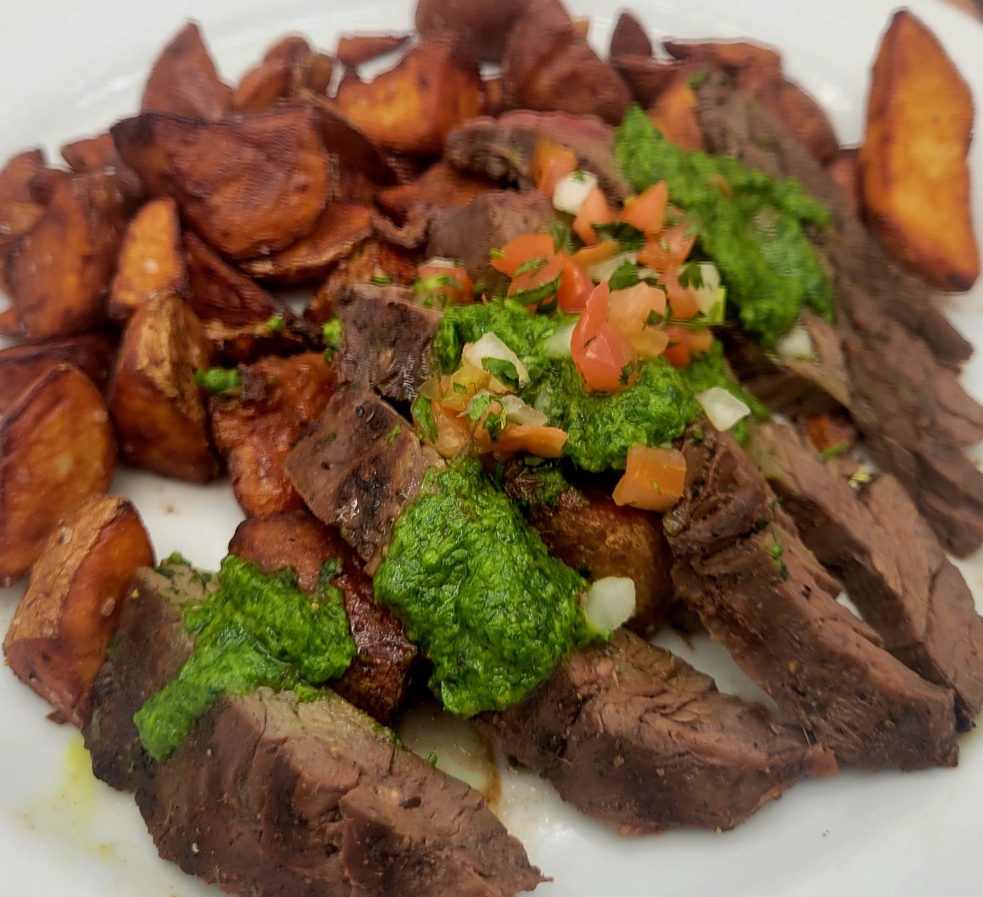 A close up of a plate of food with meat and potatoes