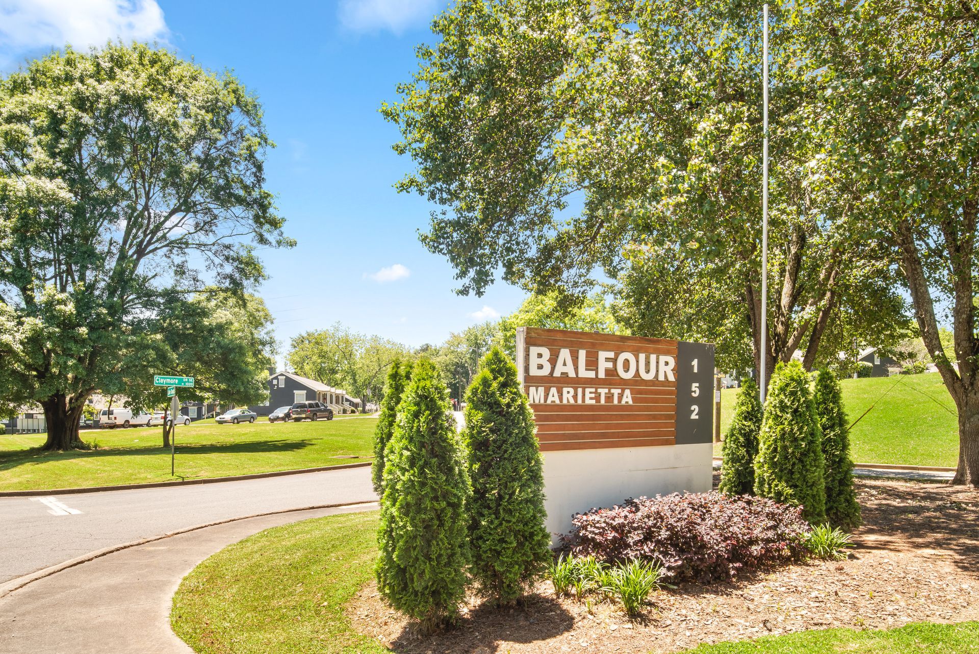 Entrance sign for Balfour Marietta in a landscaped, tree-lined park setting