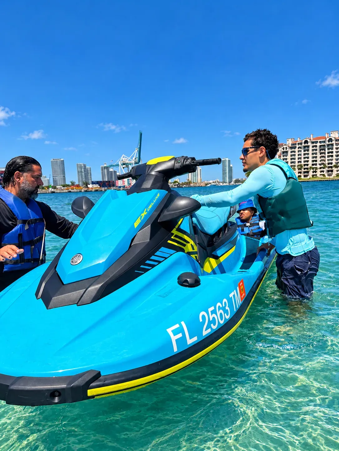 Guides assisting with a jet ski during a Fisher Island sandbar stop on a Miami jet ski tour