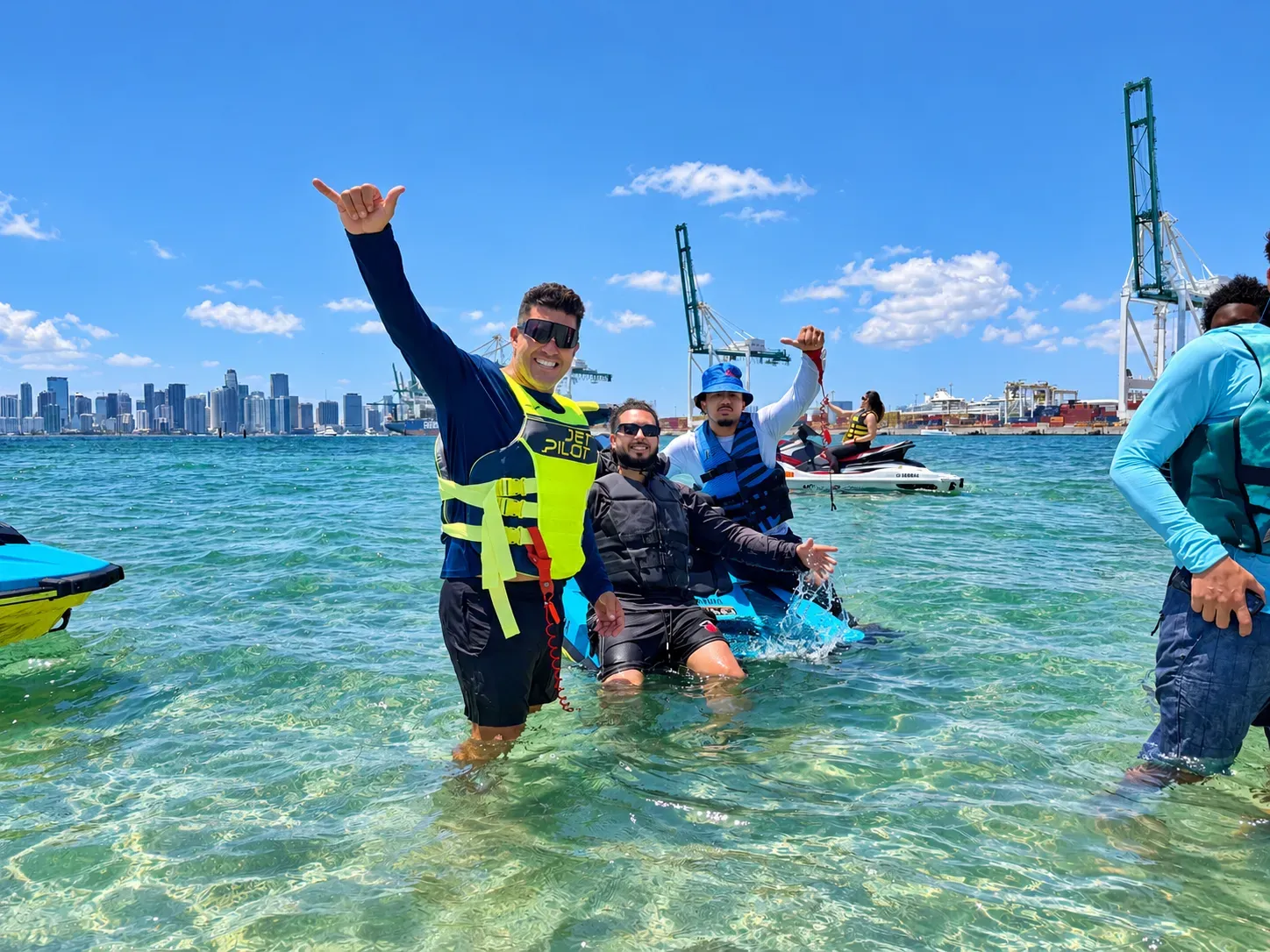 Group enjoying jet ski rentals in Miami at a shallow sandbar with the Downtown Miami skyline in the background