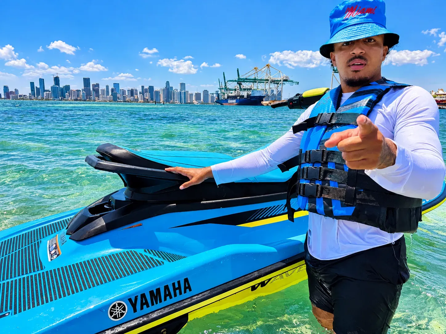 Miami guided jet ski rentals with a guide beside a Yamaha jet ski on Biscayne Bay with the Downtown Miami skyline in the background
