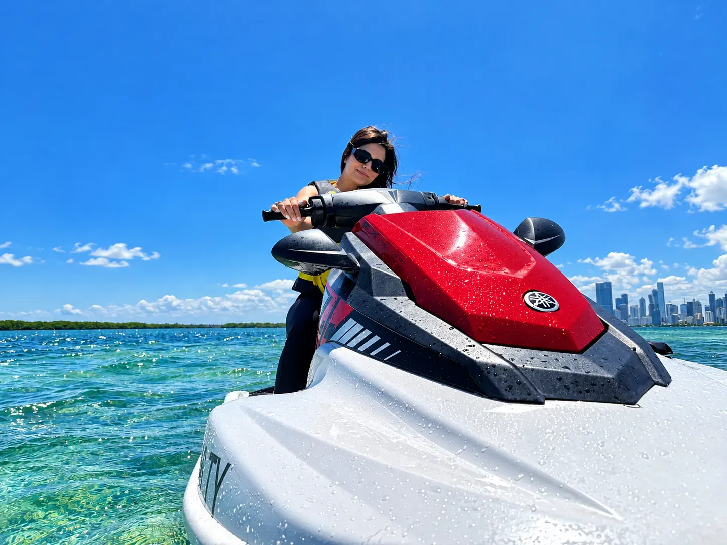 Woman riding on a Miami jet ski tour across Biscayne Bay with the Miami skyline in the background
