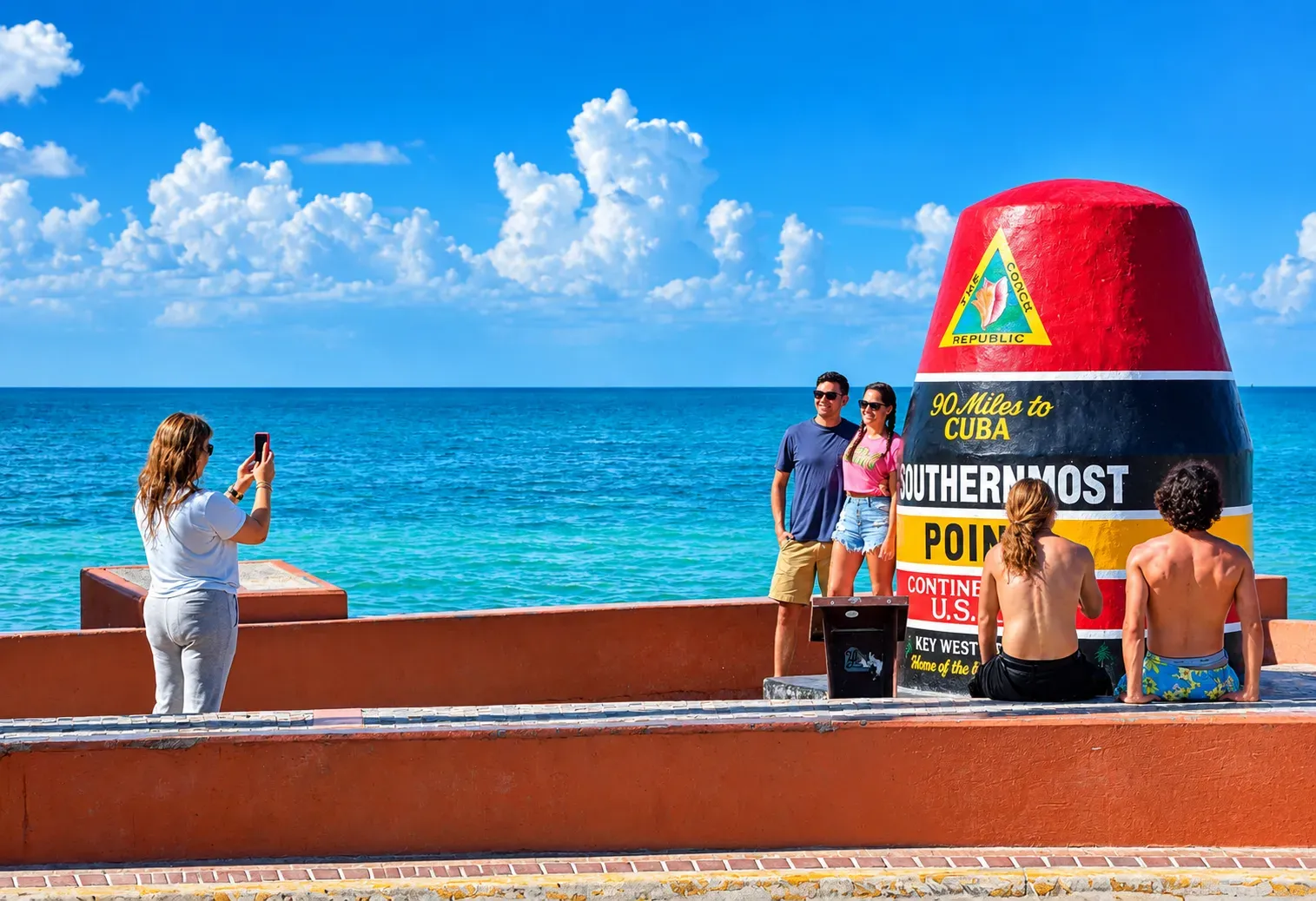 Miami to Key West day trip travelers taking photos at the Southernmost Point buoy