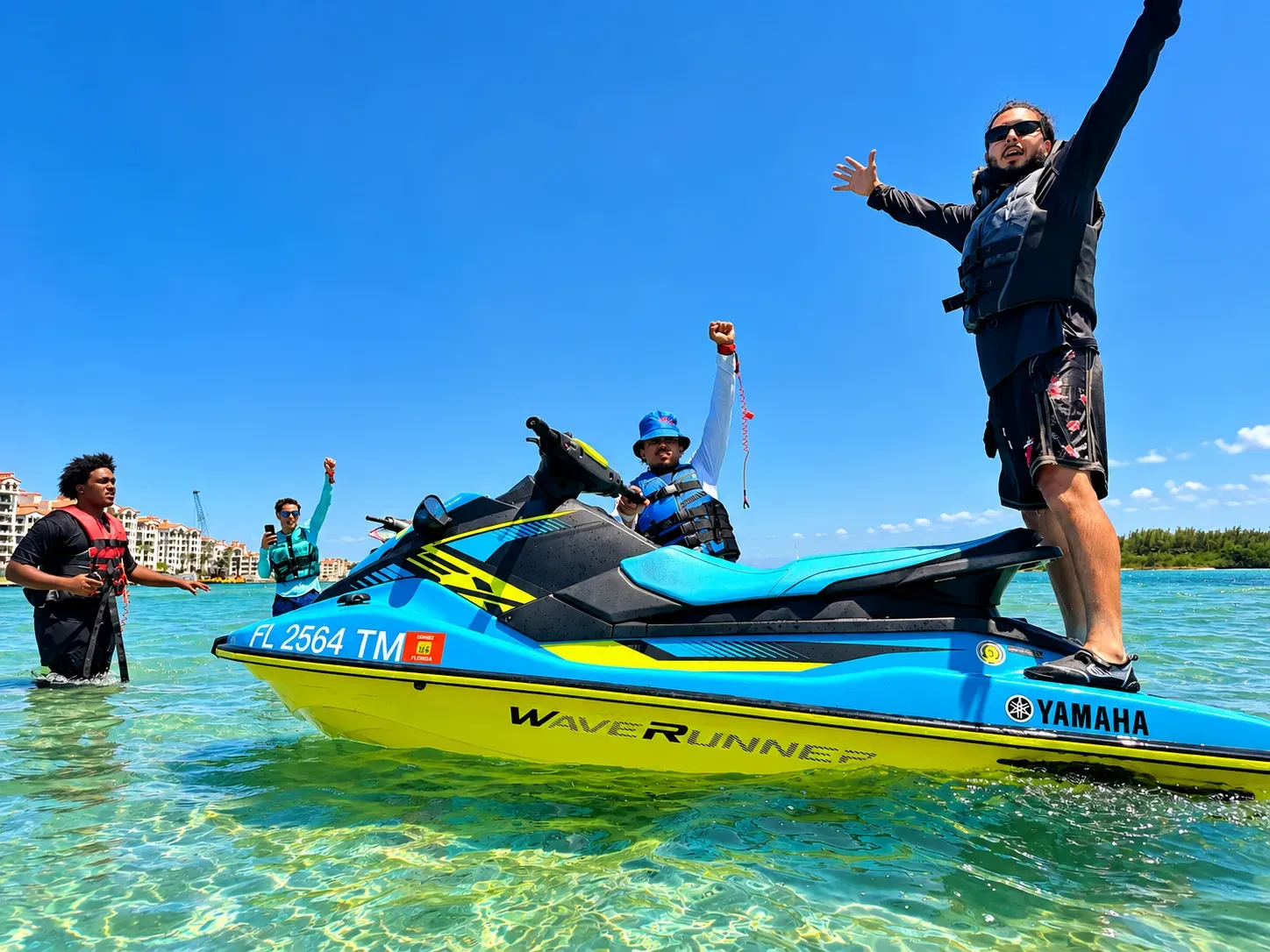 Miami tours and rentals jet ski riders with their hands up during a guided Biscayne Bay sandbar stop