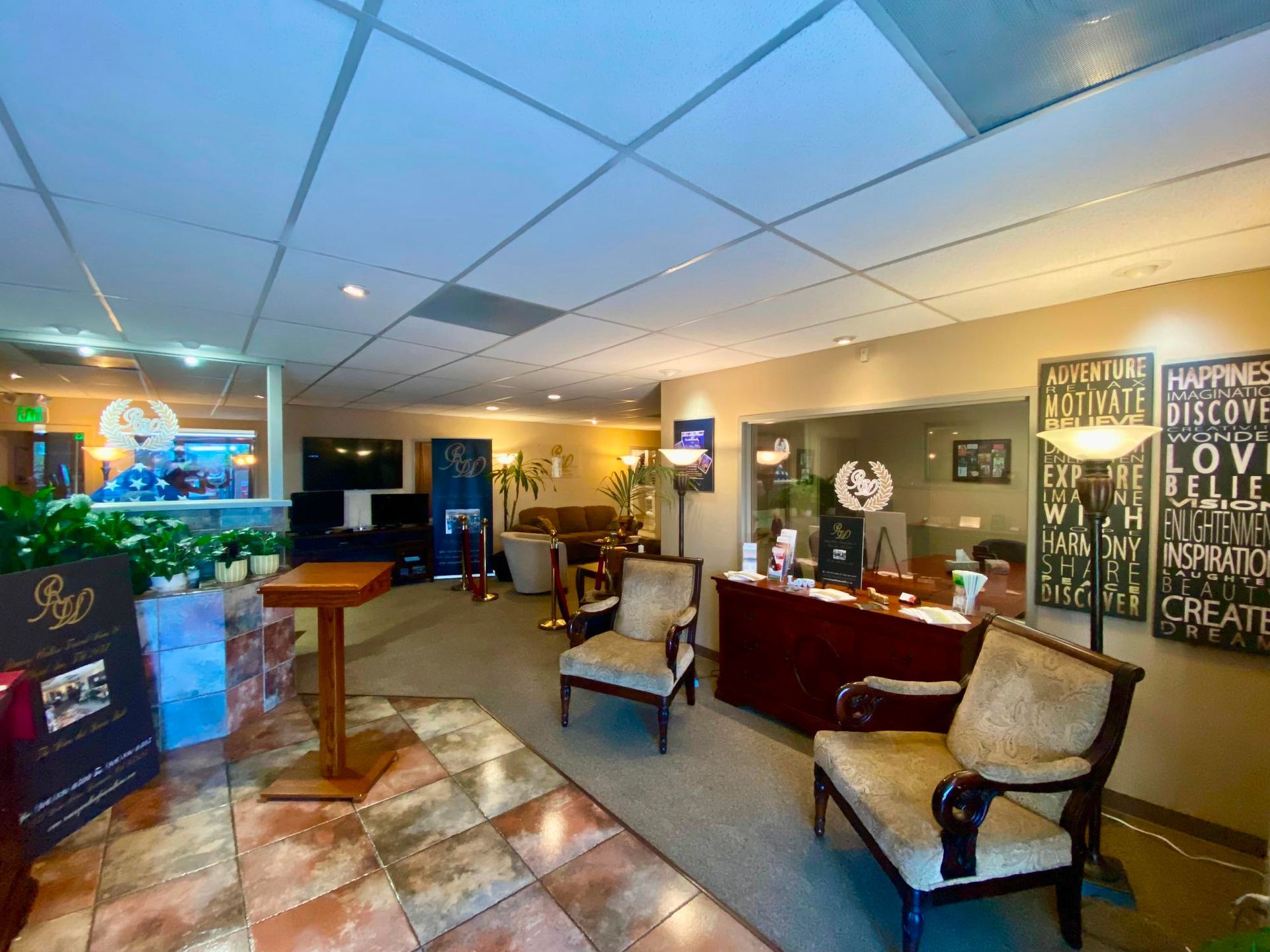 Elegant lobby with chairs, reception desk, and decorative wall art under warm lighting