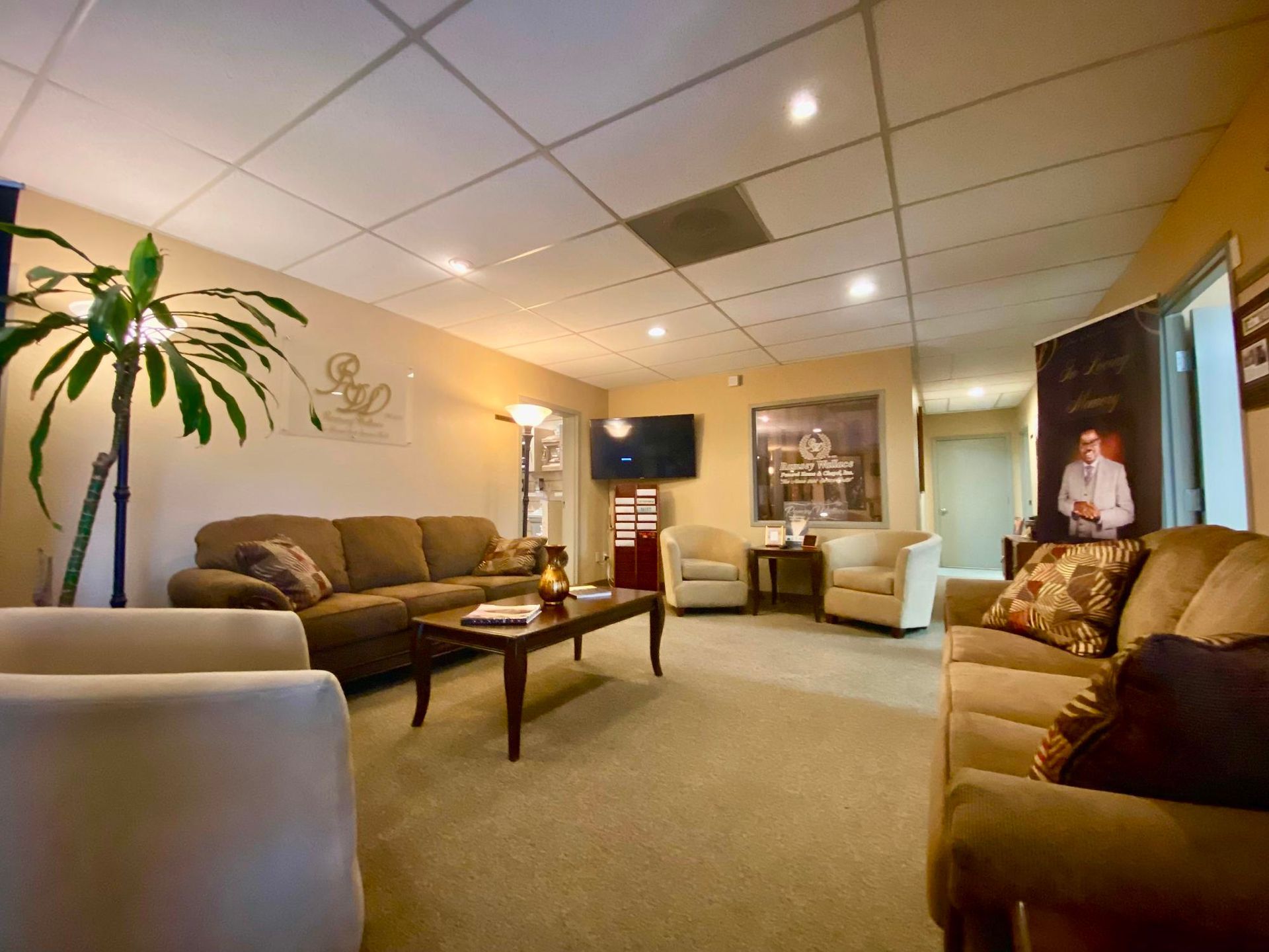 Cozy living room with beige sofas, coffee table, floor lamp, and a potted palm under warm lighting
