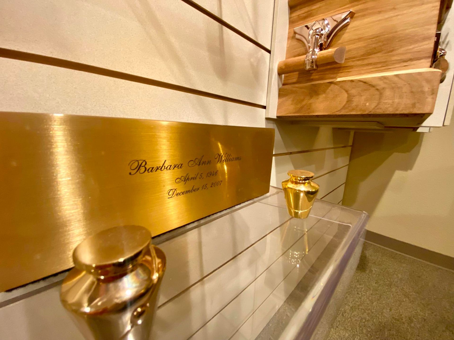Wooden staircase with gold handrails and brass plaque in a warm indoor setting
