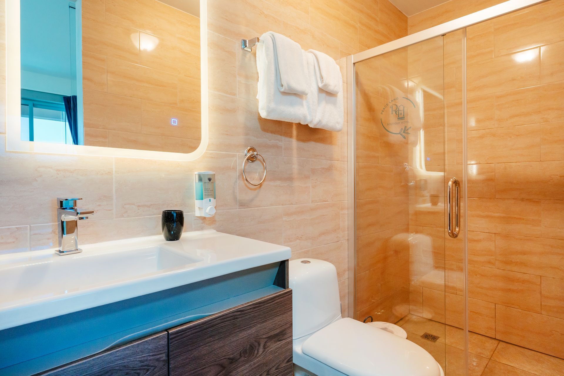Modern bathroom with sink, toilet, glass shower, and light wood tile walls