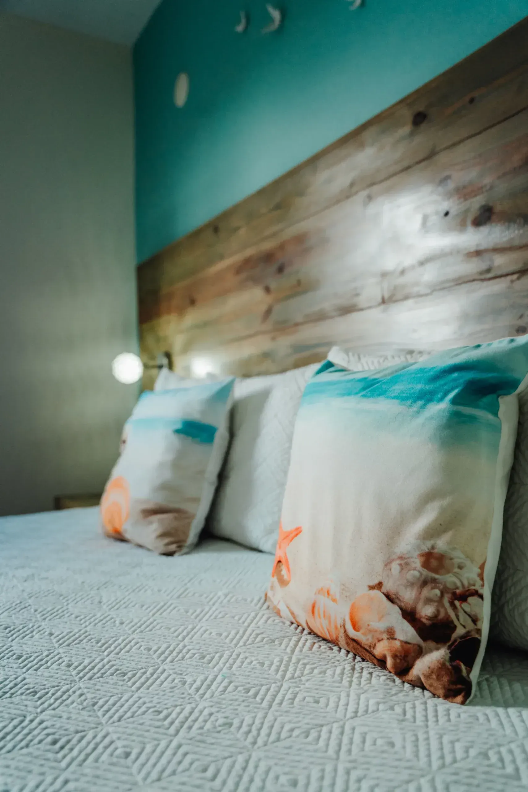 A bed with a wooden headboard and pillows on it.