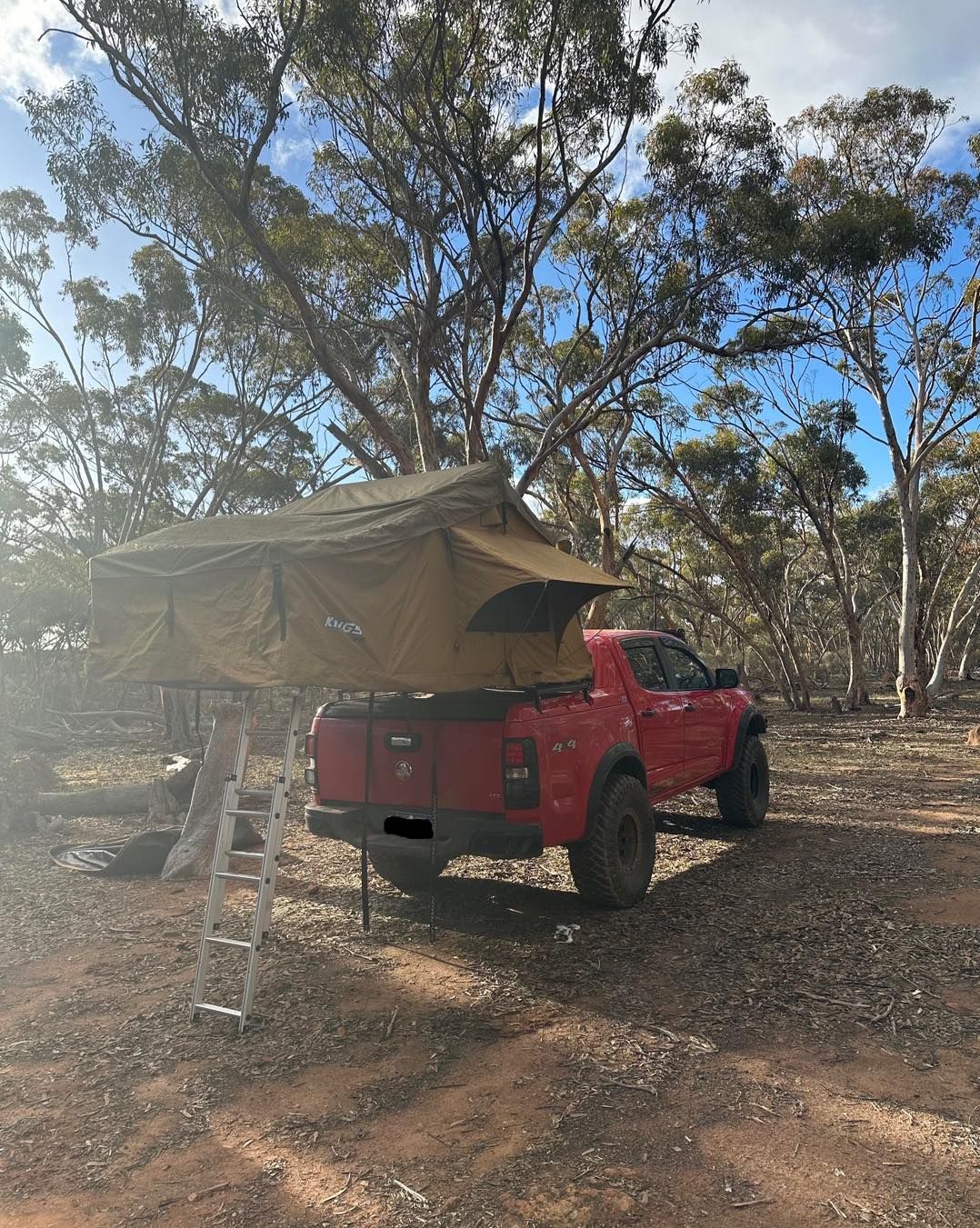 A red truck with a tent on top of it.