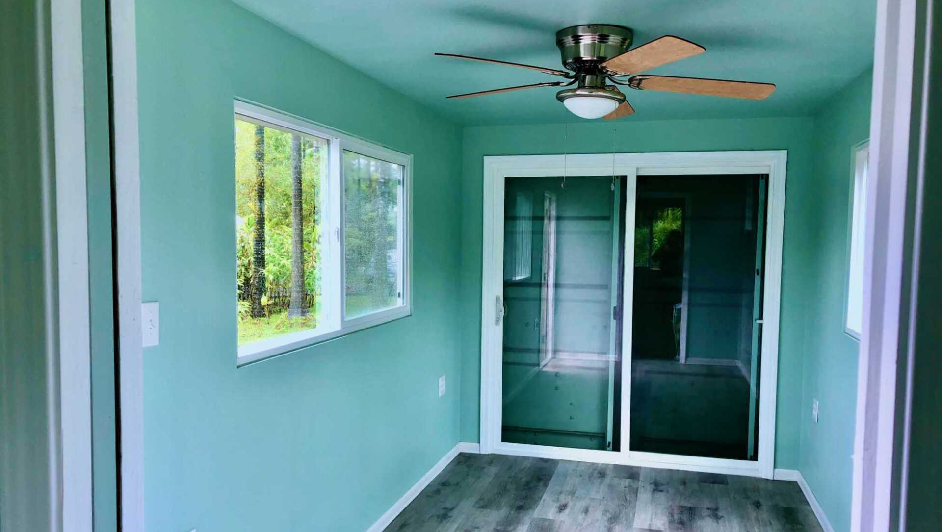 Custom Shipping Container Interior with blue green decoration and window, ceiling fan and sliding doors