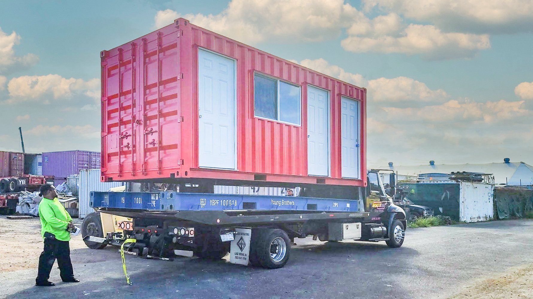 20 ft Custom Shipping Container Space with multiple doors and window and red exterior loaded for delivery
