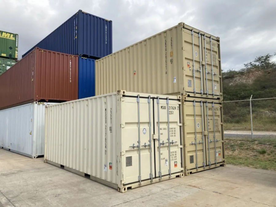 Shipping containers stacked in a holding yard for sale and for rent