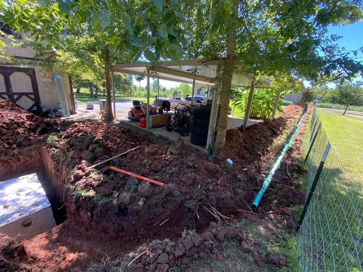 A large pile of dirt is sitting next to a fence in front of a house.