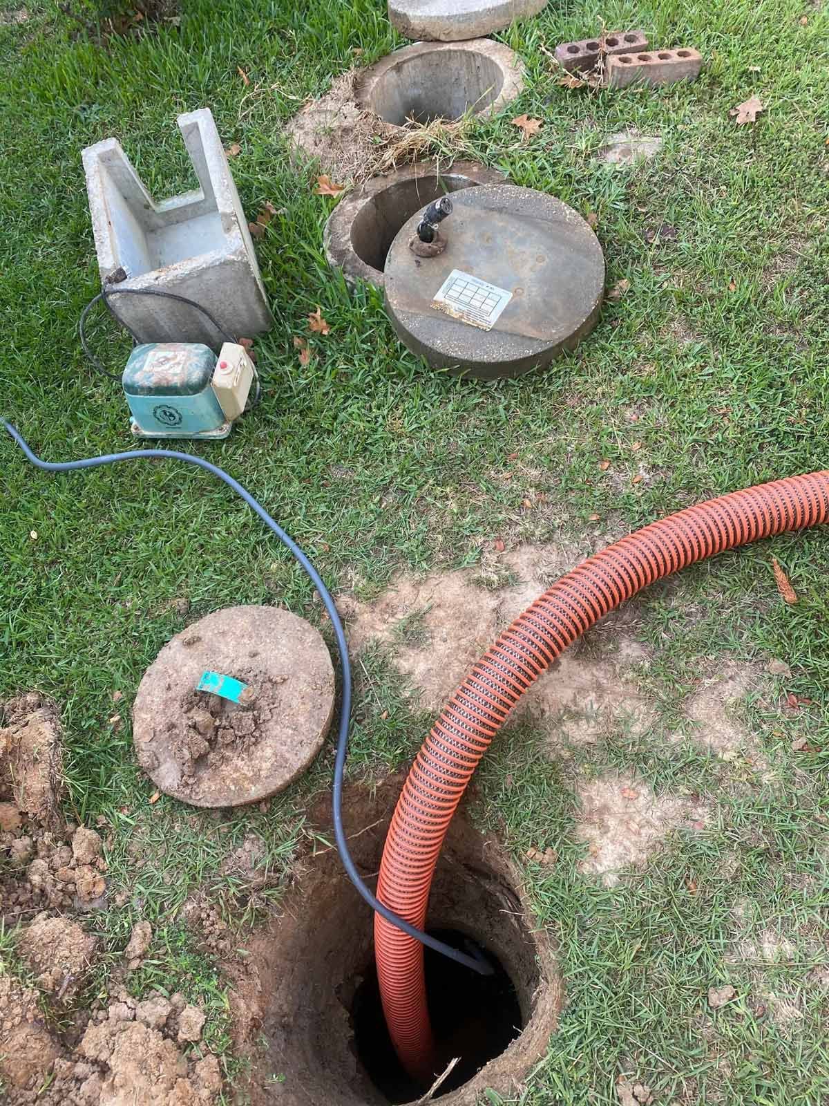 A hose is coming out of a hole in the ground.
