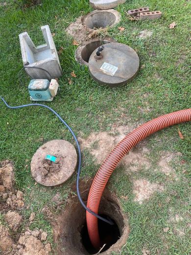 A hose is coming out of a hole in the ground.