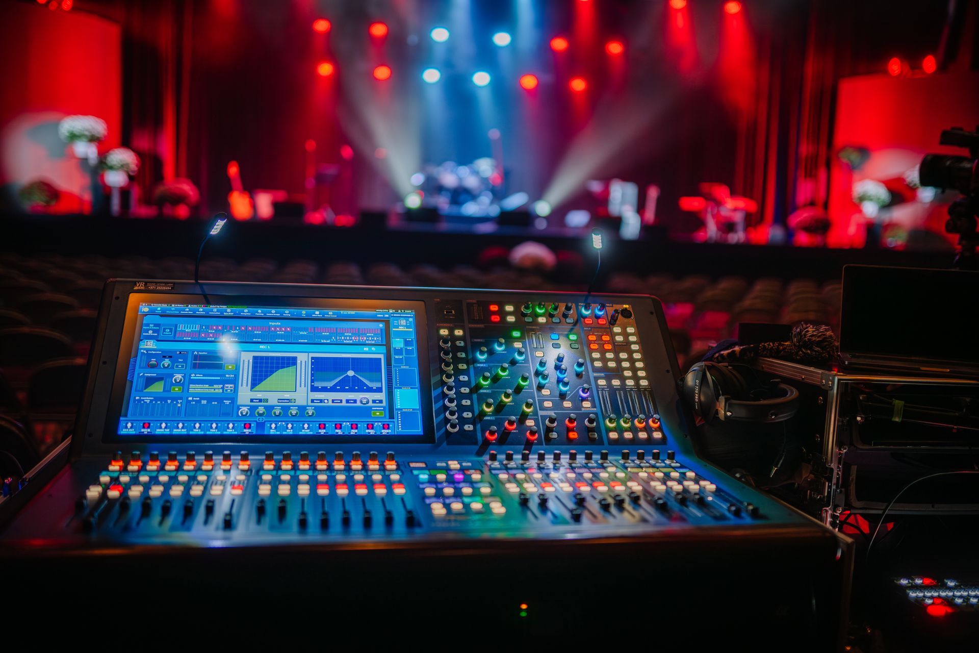 Audio mixing console with colorful lights in a concert venue before a show