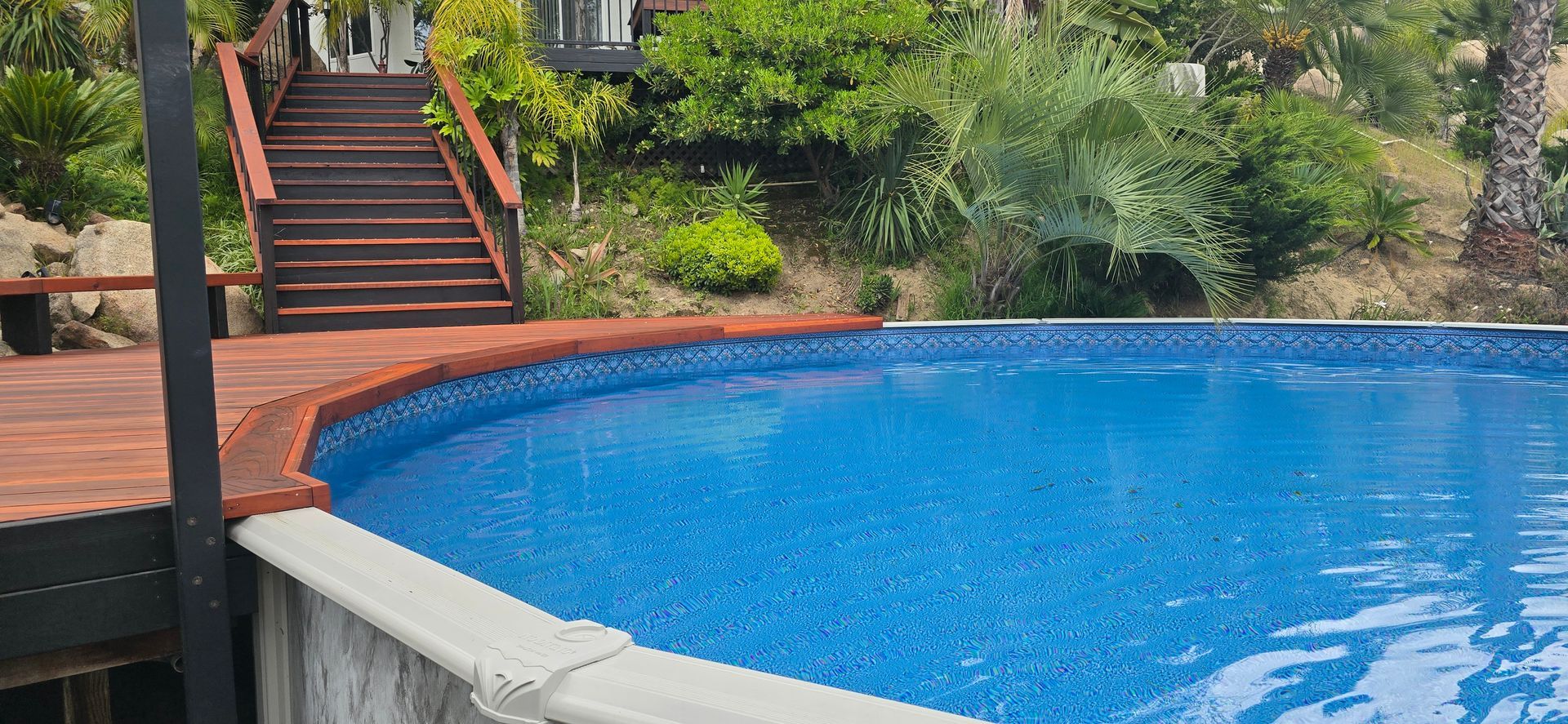 Blue swimming pool beside brick steps and lush greenery
