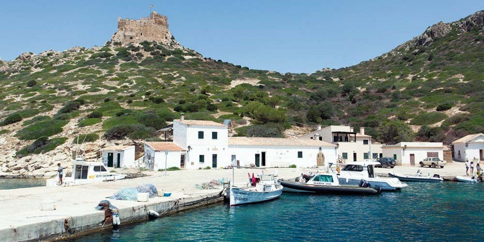 Los barcos están atracados en un puerto con un castillo al fondo.