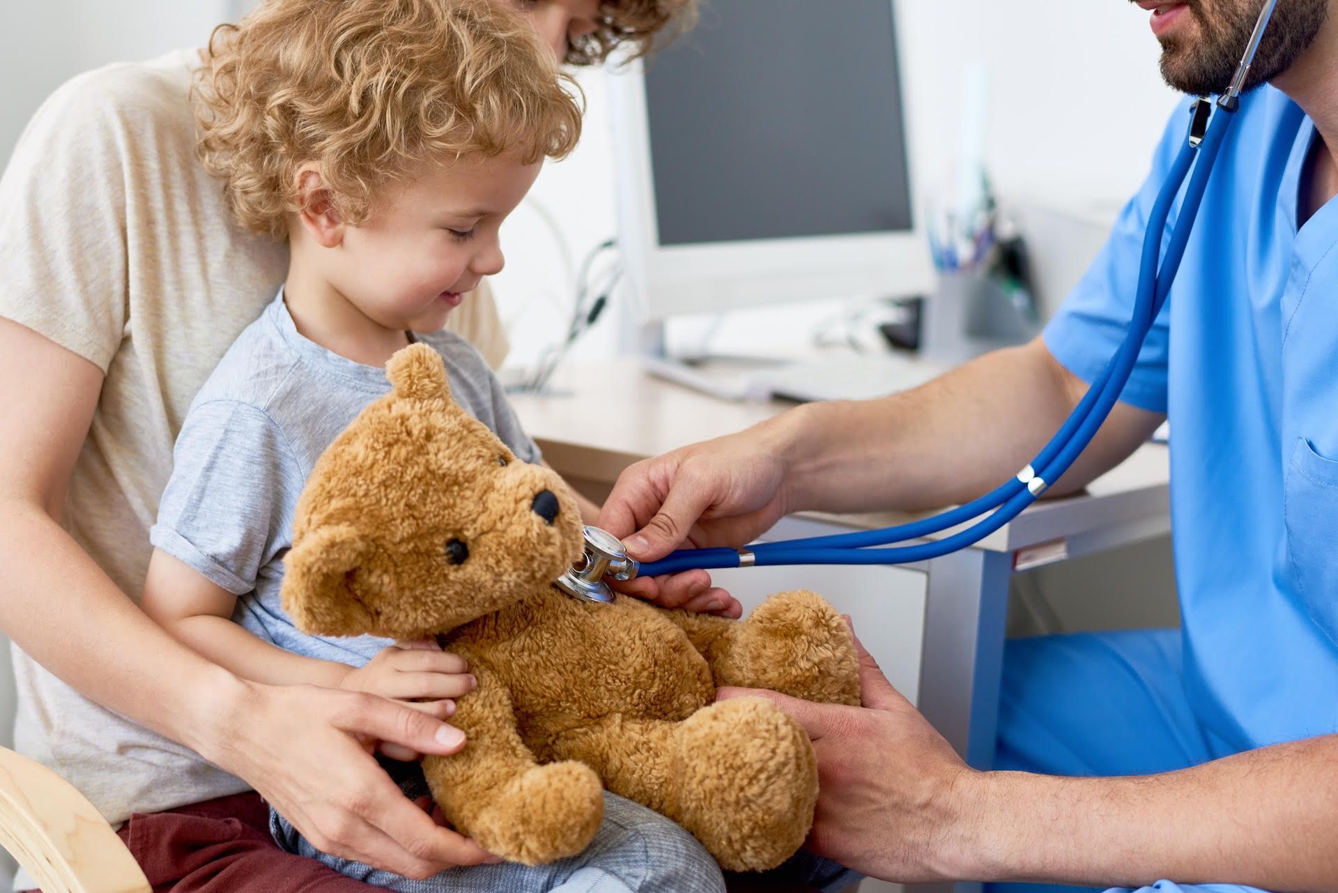 Un médico está examinando un osito de peluche con un estetoscopio.