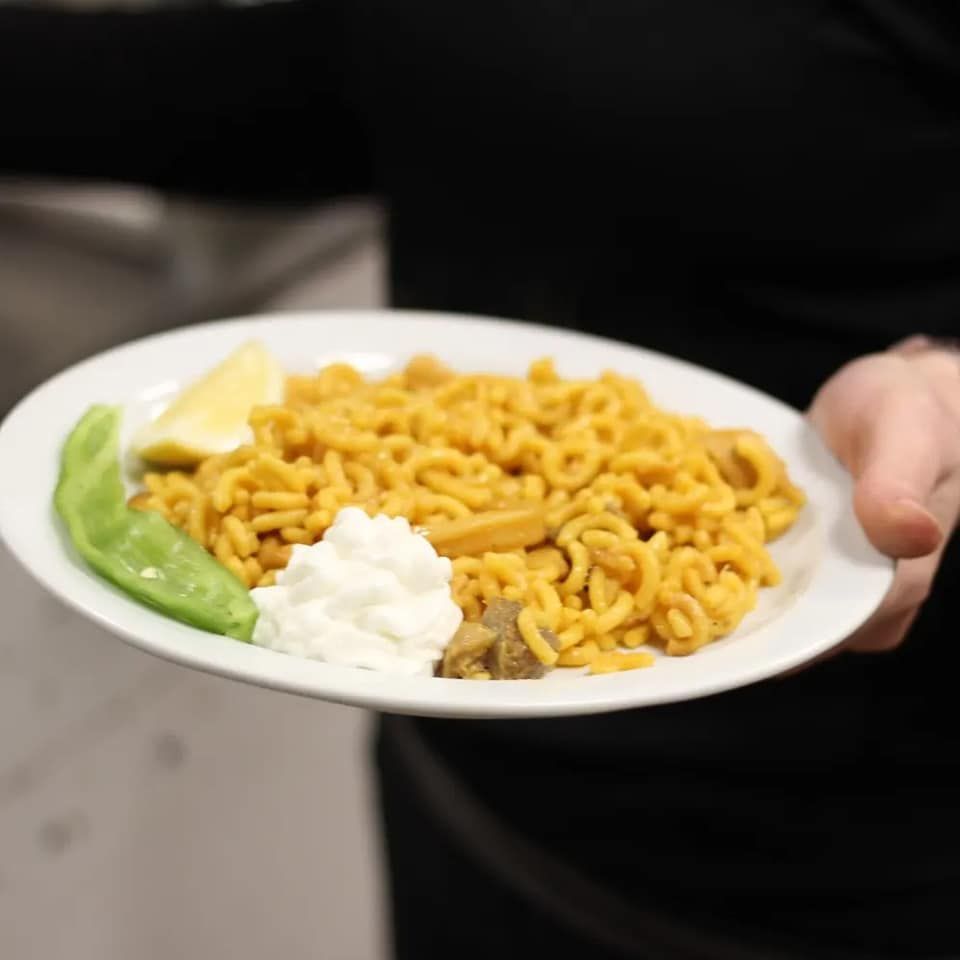 Una persona sostiene un plato de comida en su mano.
