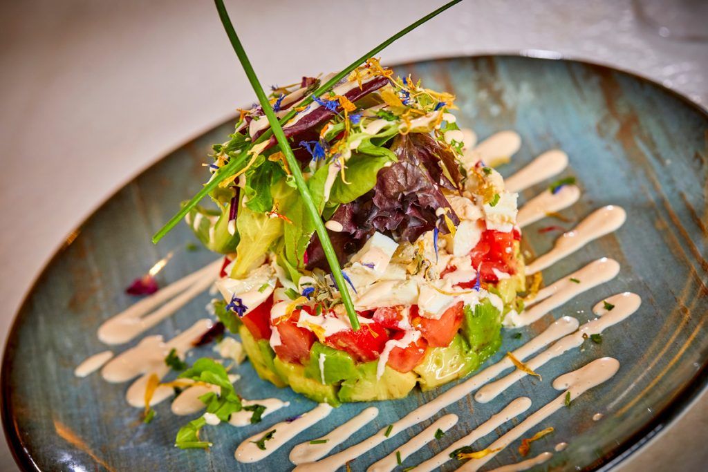 Un primer plano de una ensalada en un plato sobre una mesa.