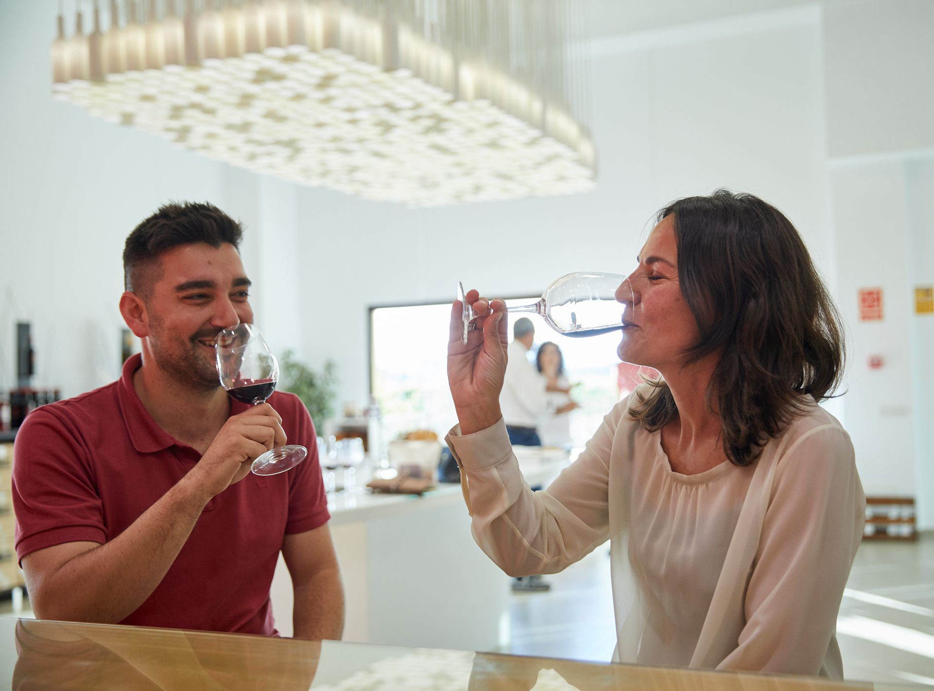 Un hombre y una mujer están sentados en una mesa bebiendo vino.