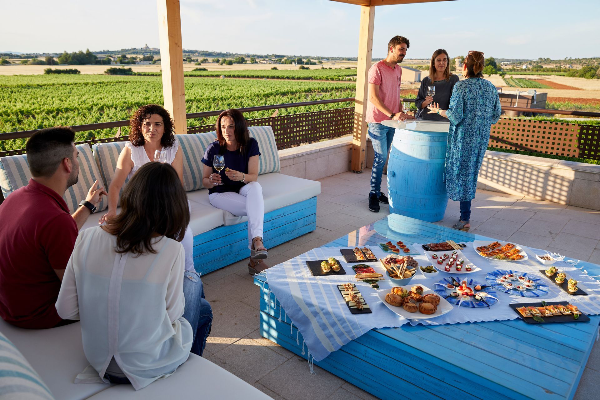 Un grupo de personas están sentadas alrededor de una mesa con comida en ella.