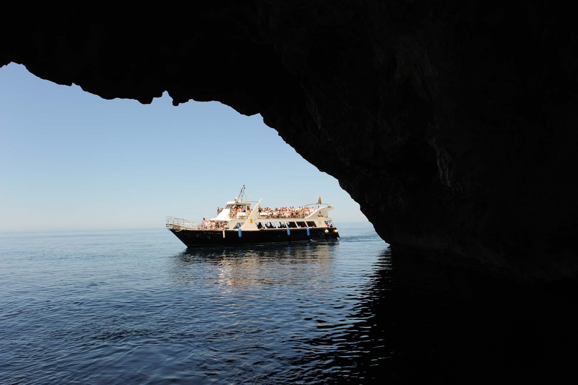 Un barco en el océano es visible a través de una cueva.