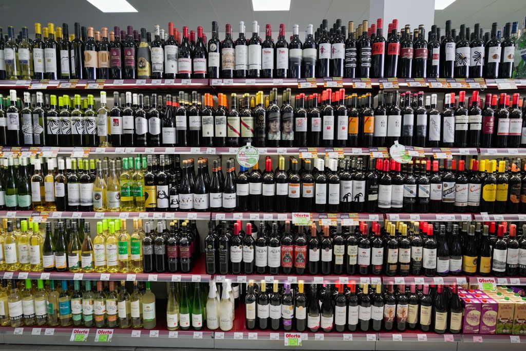 Un estante de un supermercado lleno de botellas de vino.