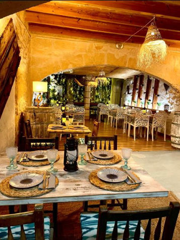 Un restaurante con mesas y sillas y platos sobre ellas.