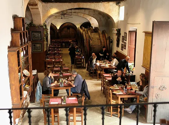 Un grupo de personas están sentadas en las mesas de un restaurante.