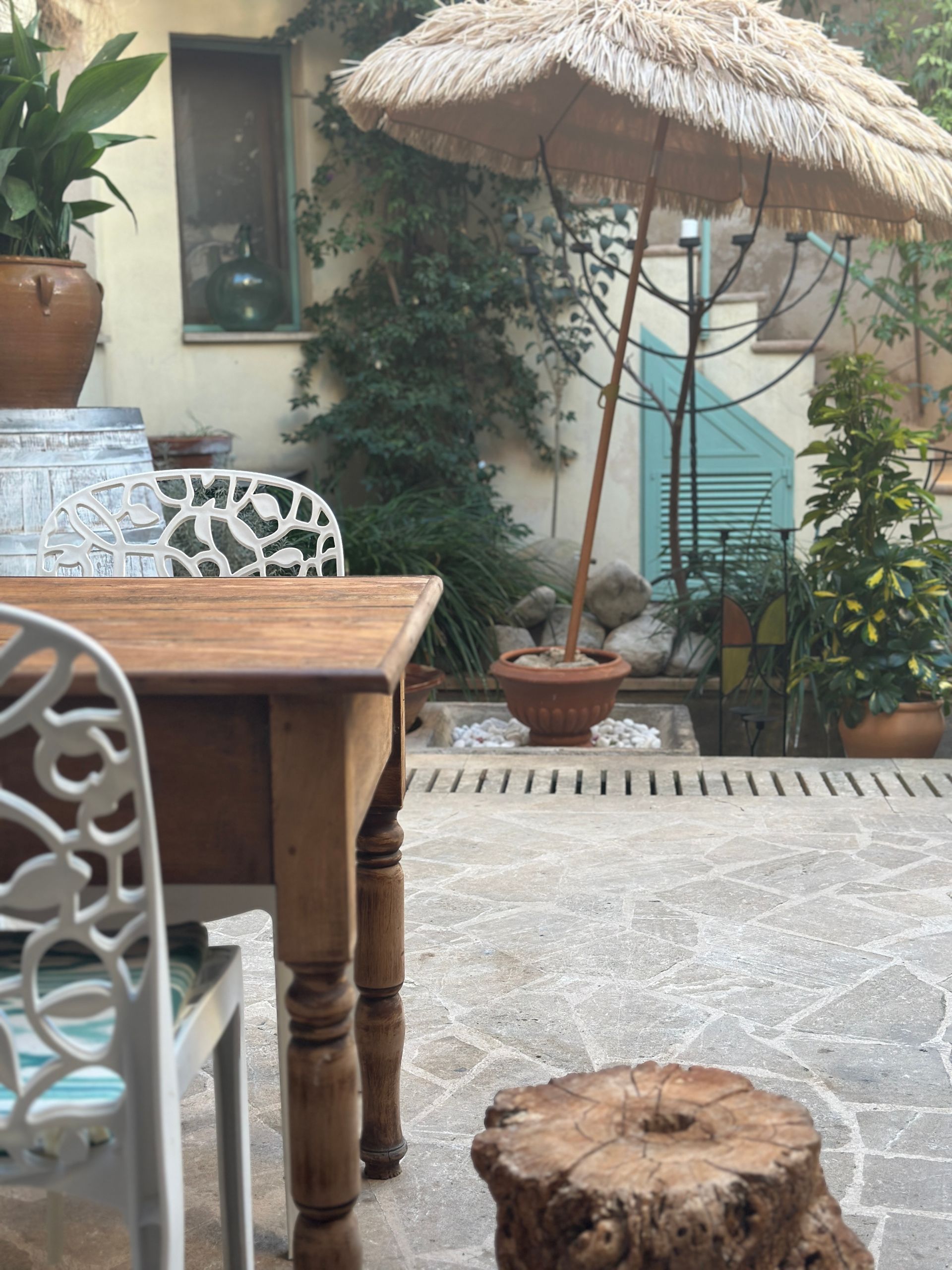 Una mesa y sillas en un patio con una sombrilla.