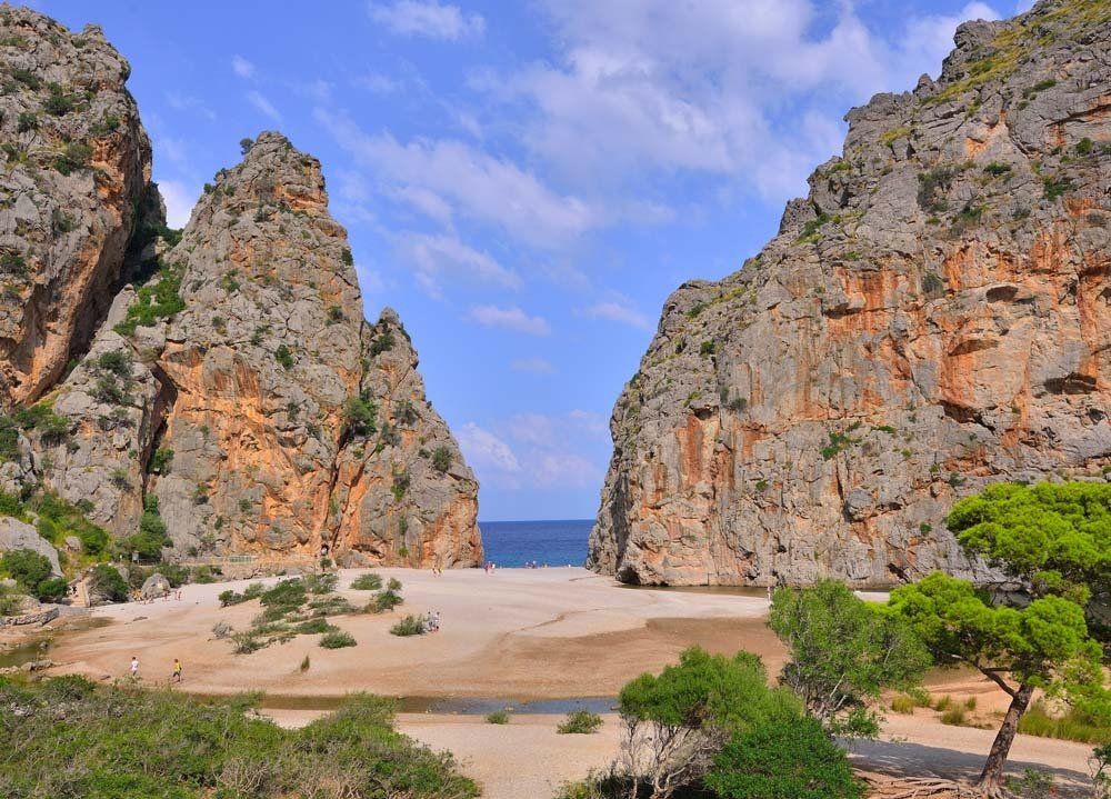 Una vista de una playa entre dos montañas rocosas.