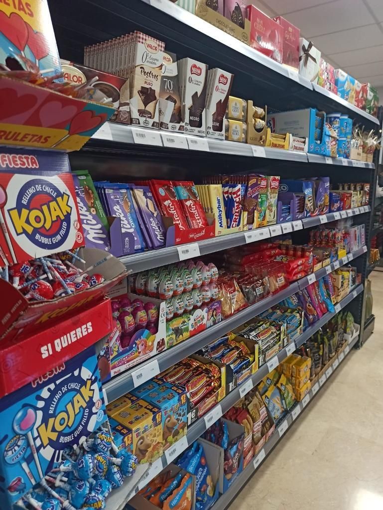Un pasillo de una tienda de comestibles lleno de dulces y bocadillos.