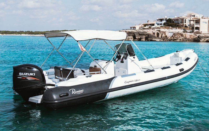 Un barco blanco y negro con un dosel flota sobre un cuerpo de agua.