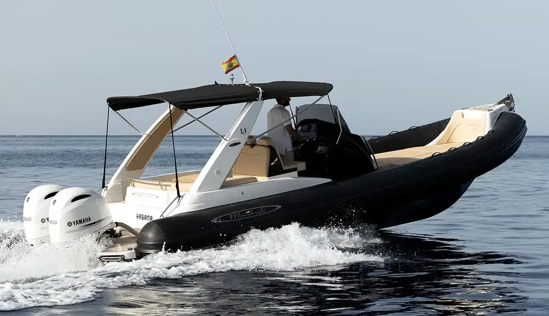Un barco blanco y negro flota sobre un cuerpo de agua.