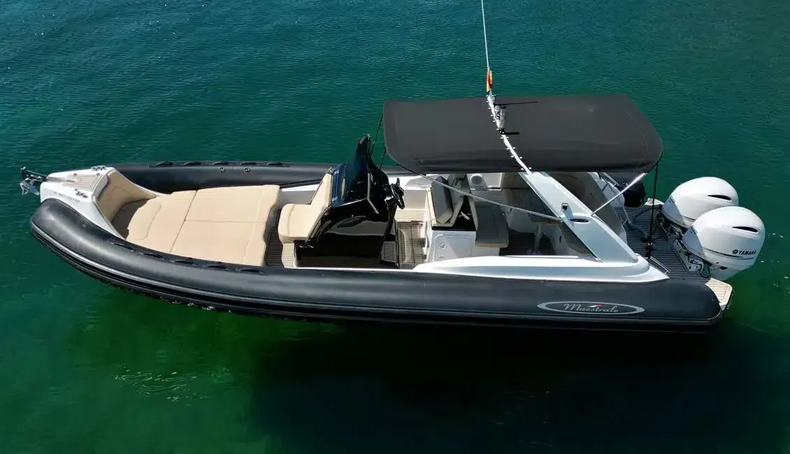 Un barco blanco y negro flota sobre un cuerpo de agua.